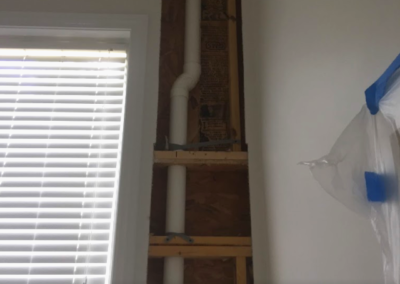 emergency plumbing services fixing a pipe that leaked in a wall