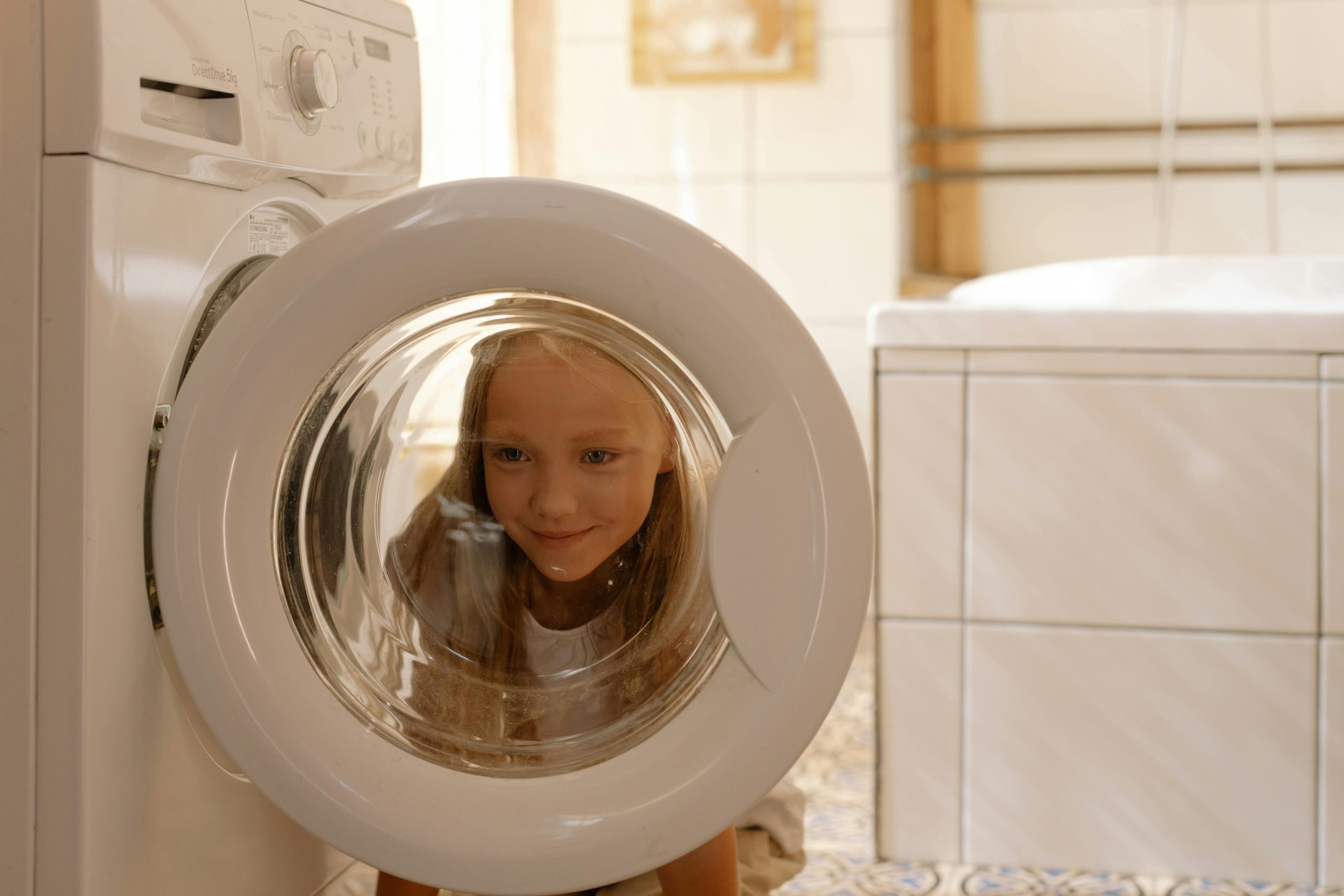 girl looking through washer machine